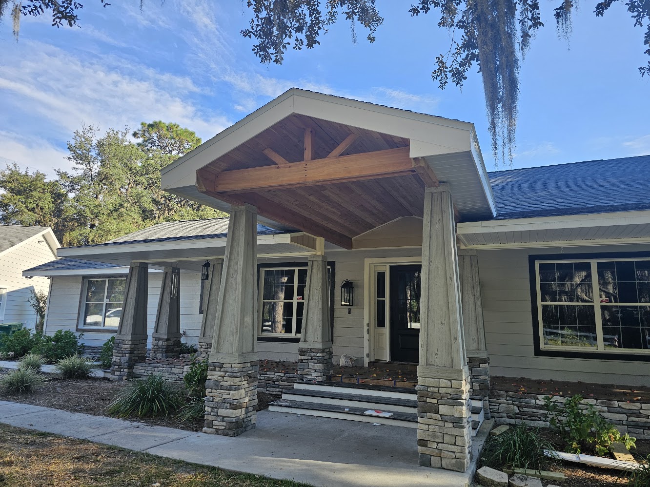 Completed covered entry with timber ceiling and stone columns