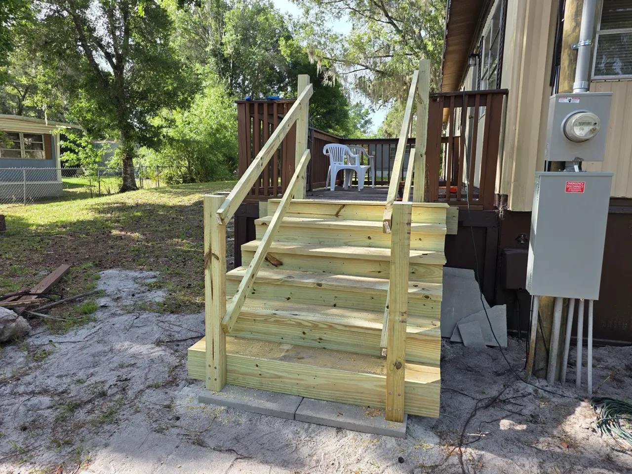 Rebuilt pressure-treated deck stairs and rail on an iFIXED handyman job