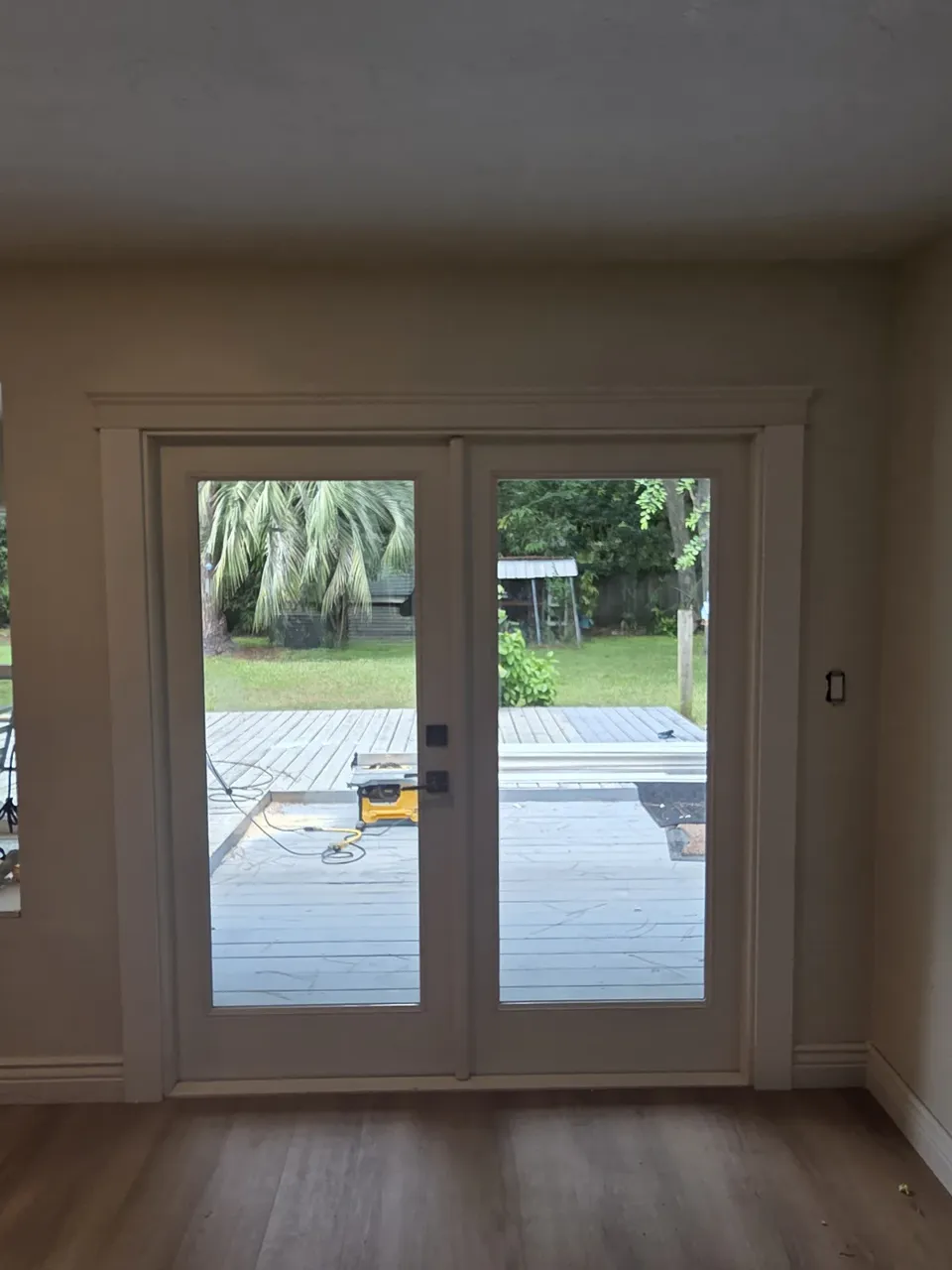 New French doors with full-lite glass seen from inside, LVP floor installed