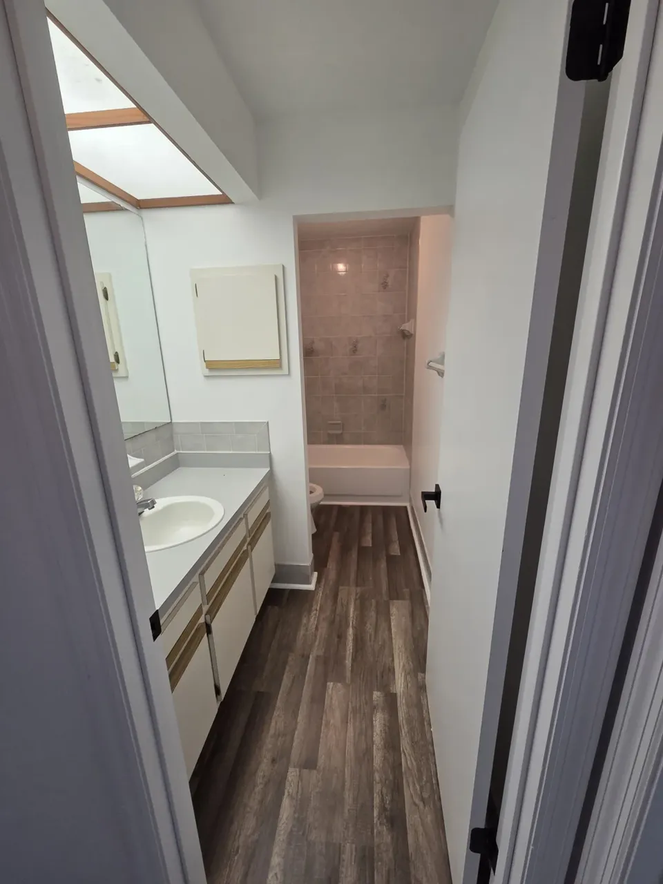 Ocala bathroom after: grey LVP plank flooring and fresh white paint