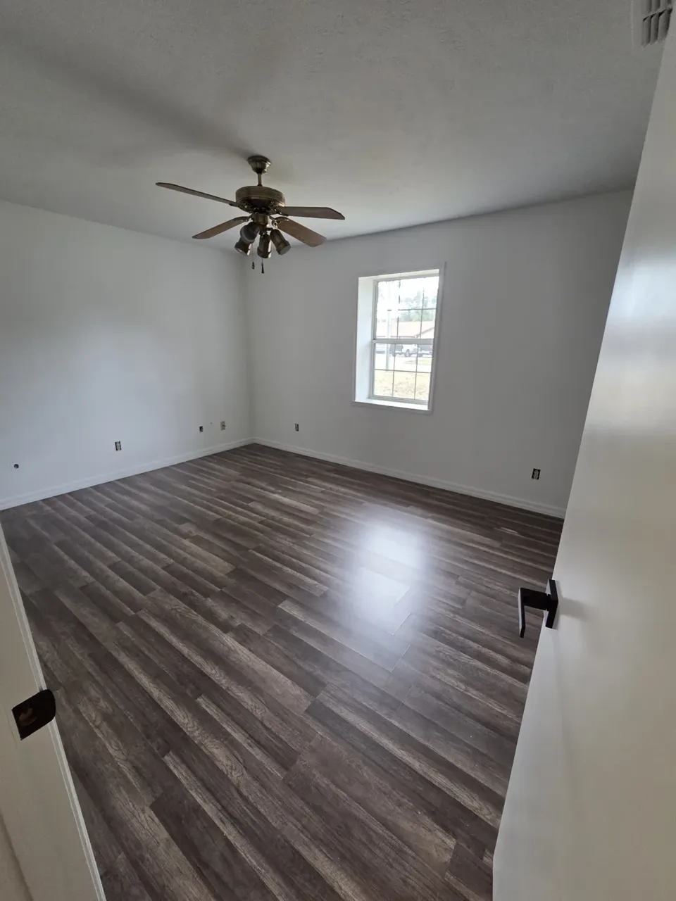 Ocala bedroom after: grey LVP plank flooring and fresh white paint