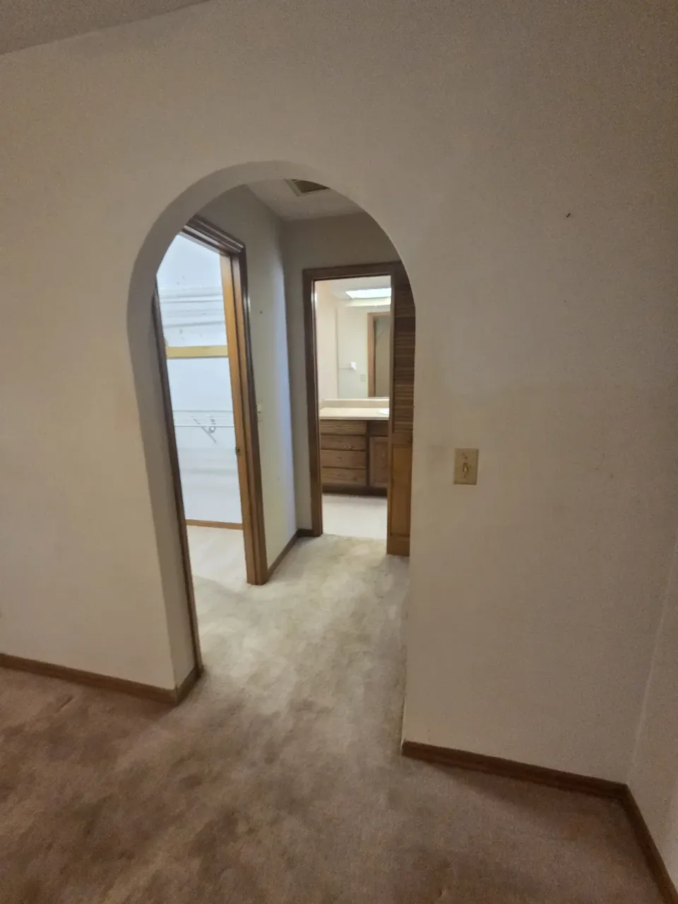 Ocala arched hallway before: worn carpet and dated paint