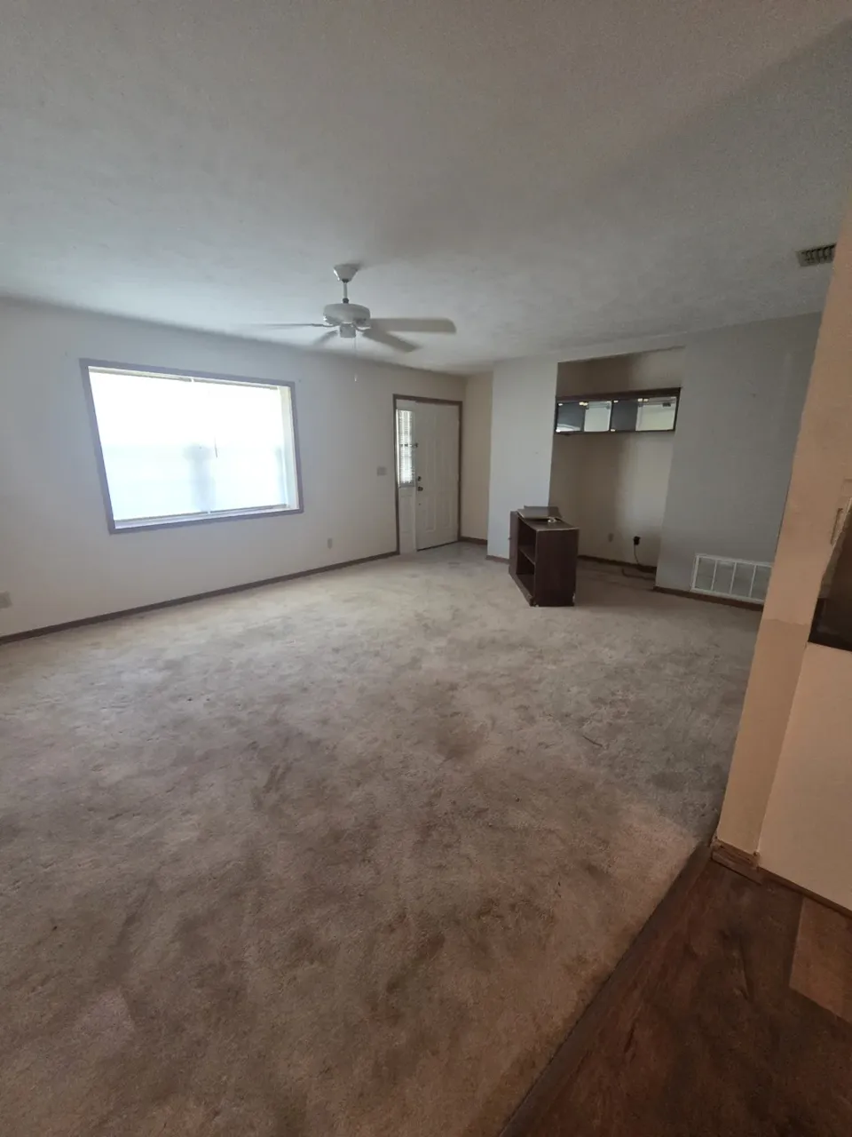Ocala living room before: worn carpet and dated paint